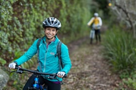 Female biker standing with mountain bike in countryside